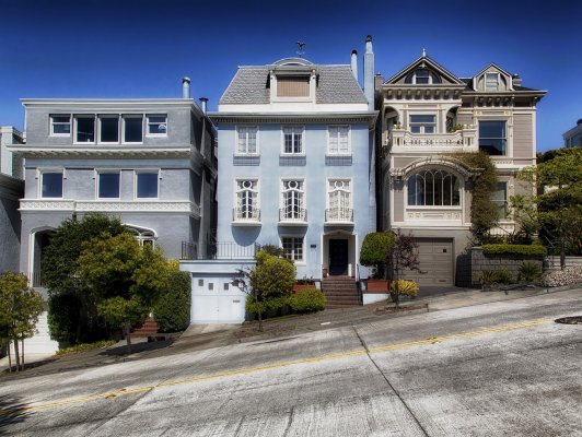 three houses on a slanted road